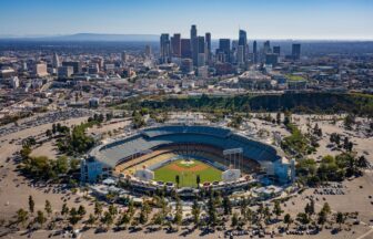 an aerial view of a baseball stadium with a city in the background