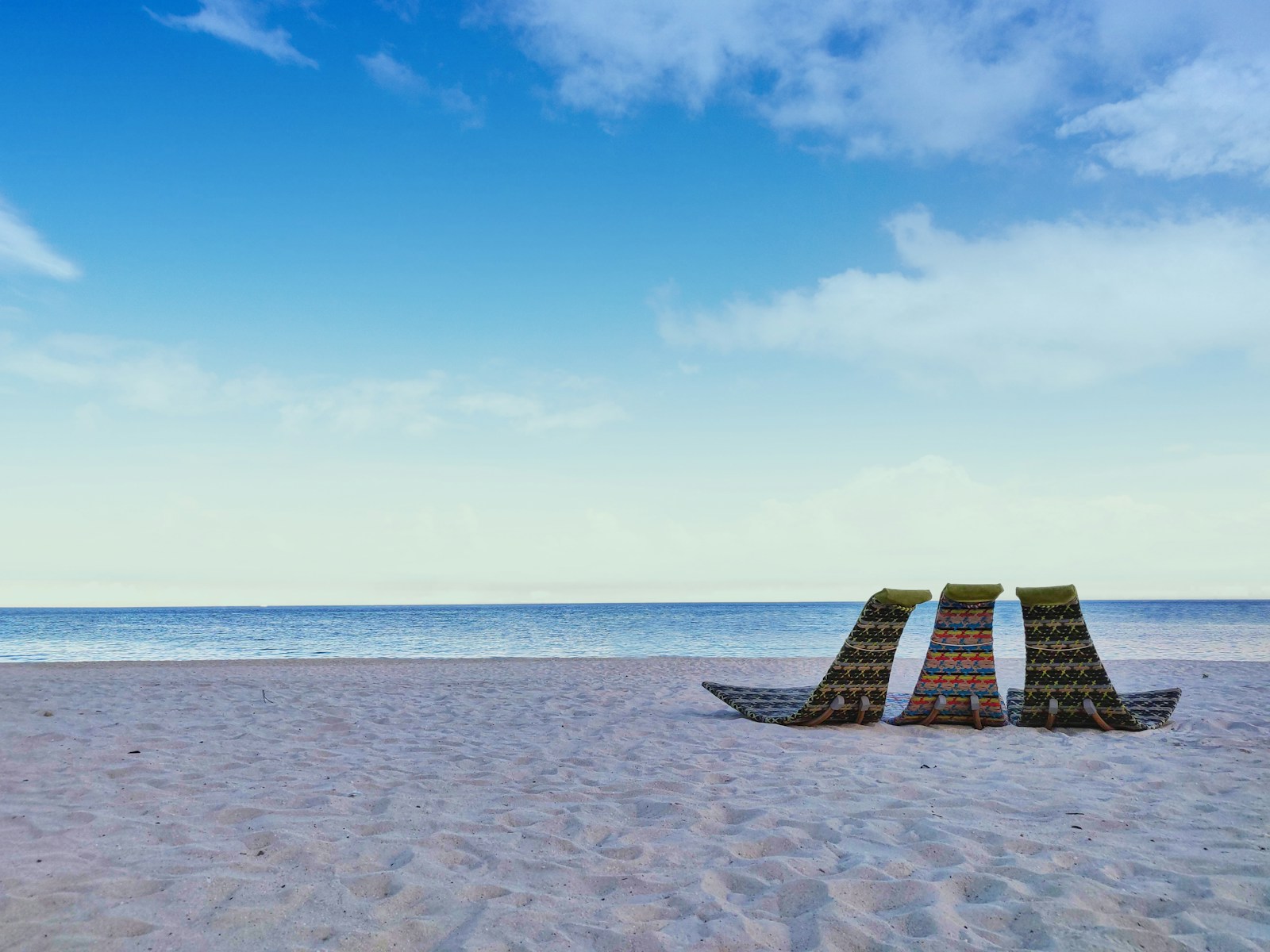 brown and white beach lounge chair on beach during daytime