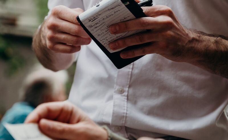 man in white button up shirt holding black and white box