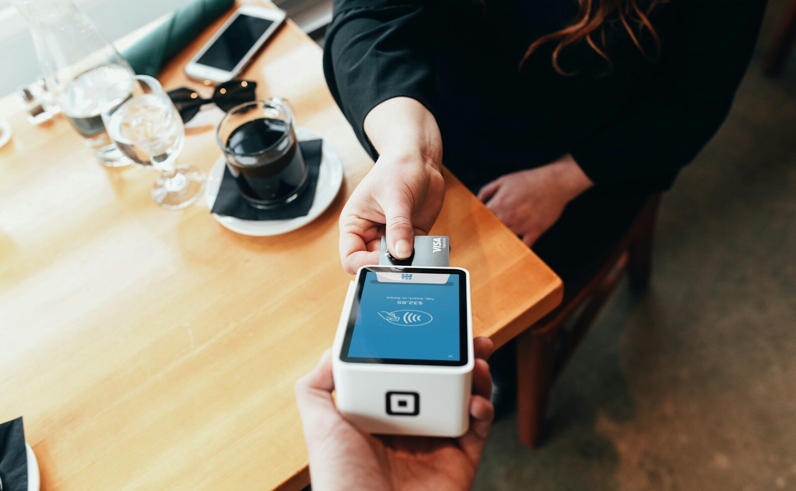 person holding credit card swipe machine