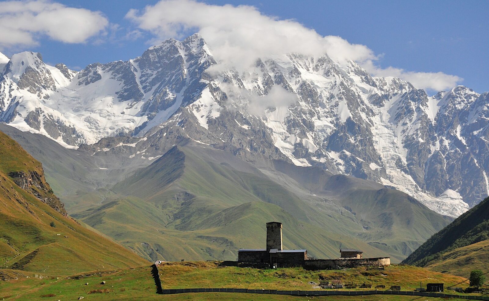 a mountain range with a building in the foreground