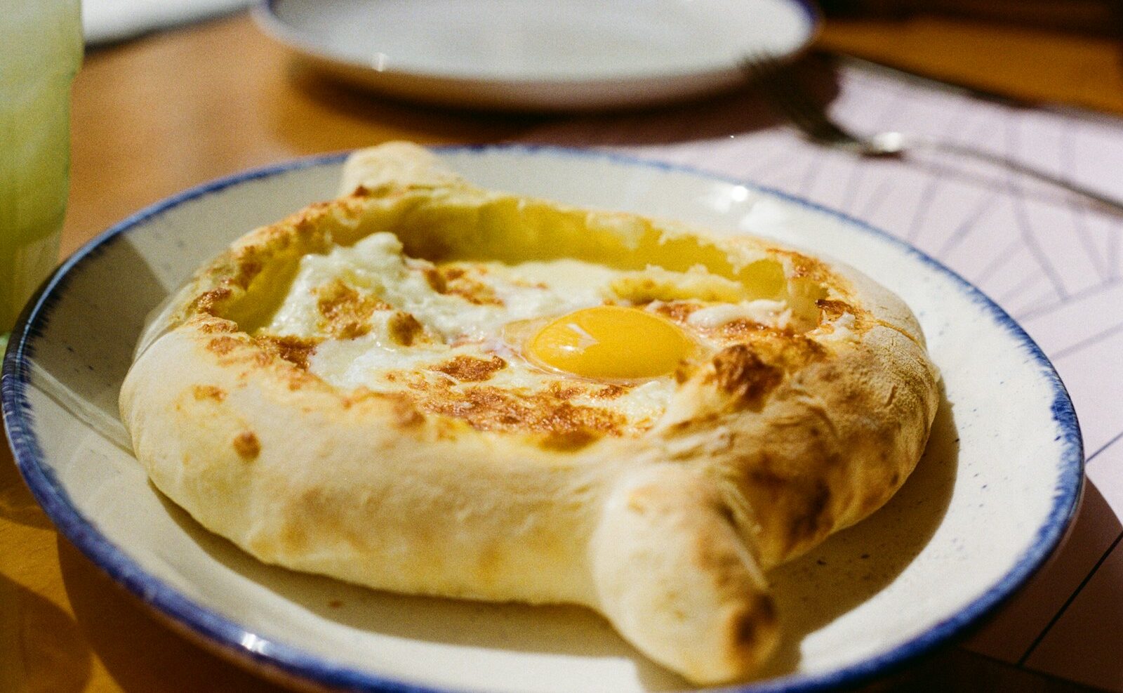 Khachapuri, a georgian bread dish, sits on a plate.