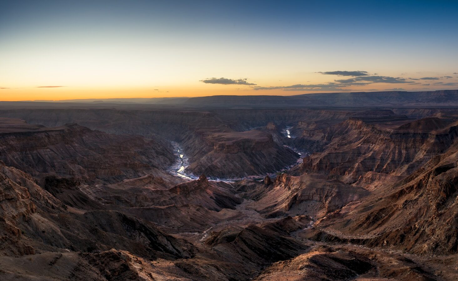 the sun is setting over the mountains in the desert