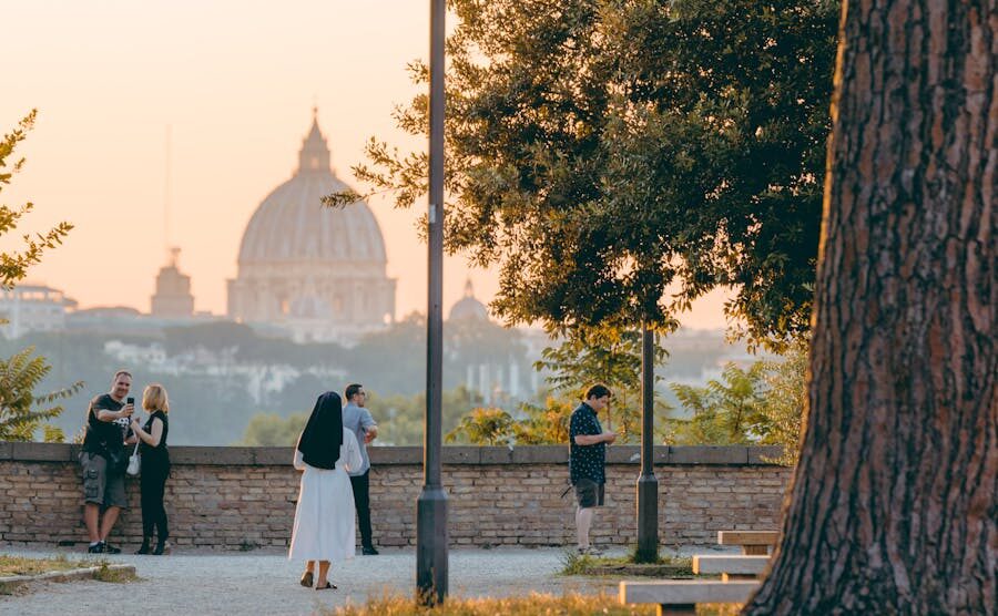 Peaceful sunset overlooking St. Peter's Basilica from a park in Rome.